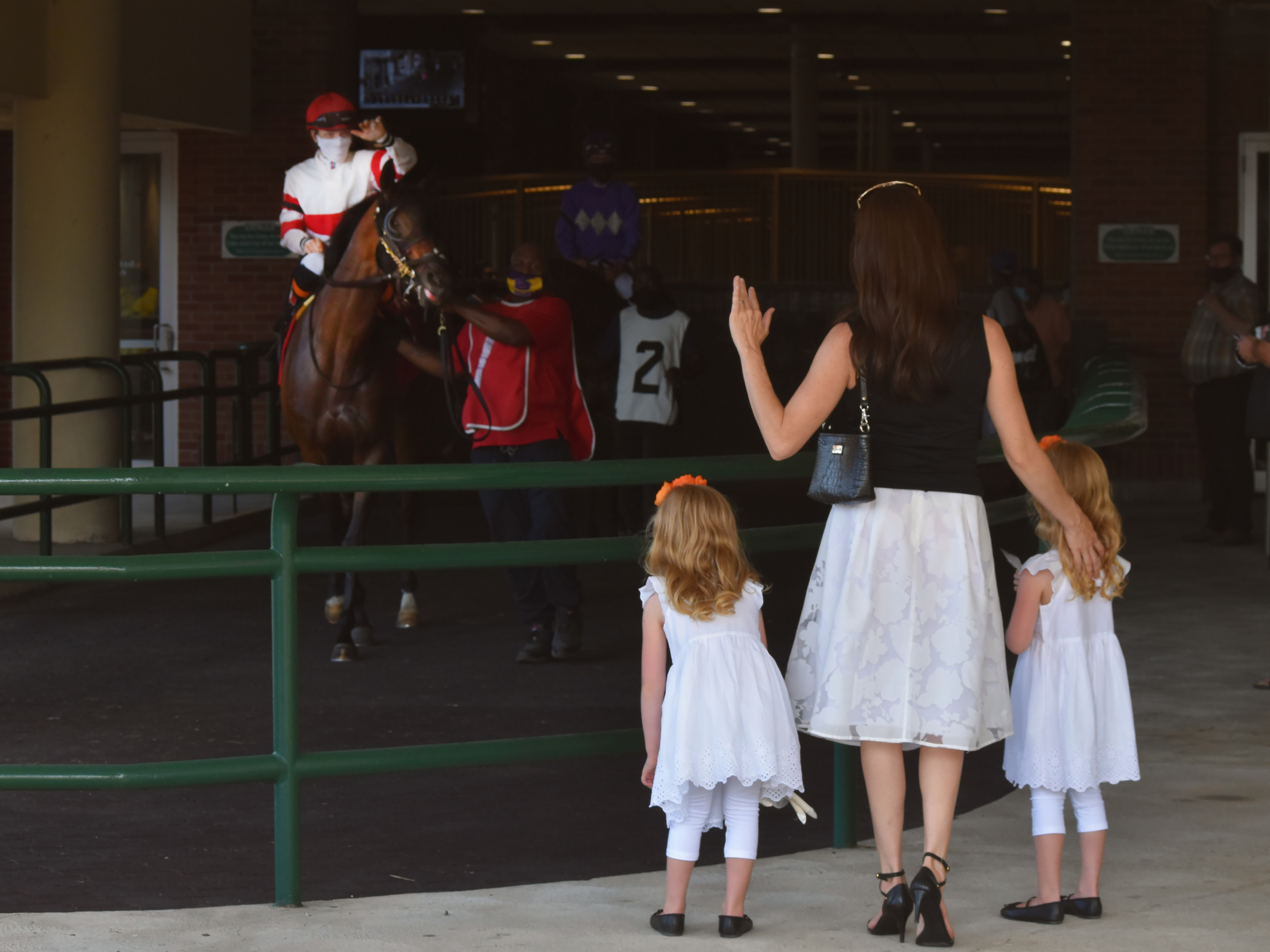 Jockey Emma-Jayne Wilson takes a moment to greet her wife Laura Claire Trotter and their daughters Grace and Avery, heading to post parade. A warm welcome back after a year of no spectators at Woodbin